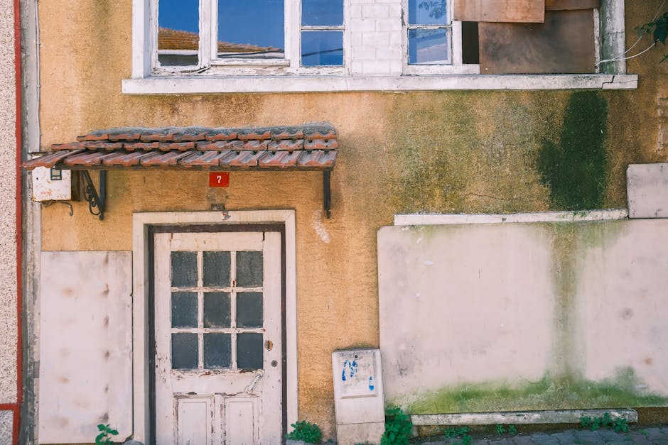 A rustic vintage doorway beneath a tiled awning on a weathered building facade.