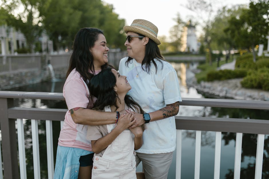 A happy family embracing on a bridge during a sunny summer day by the river.
