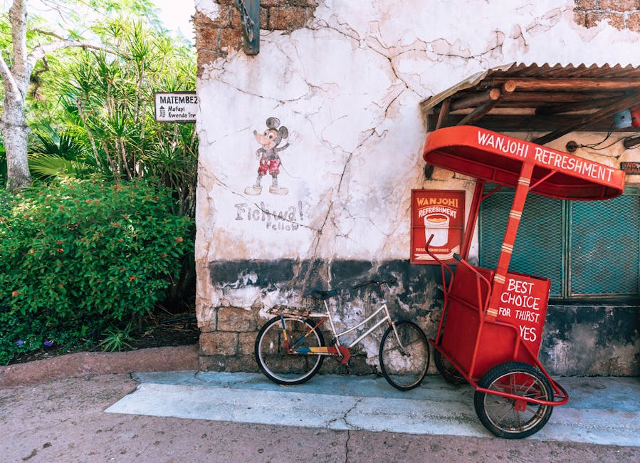 A vibrant red refreshment cart against a themed wall in Disney's Animal Kingdom, Bay Lake, Florida.