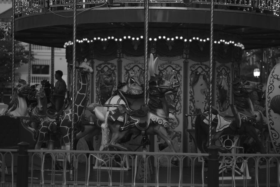 A nostalgic black and white photo of a carousel with ornate designs at night.