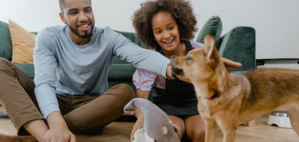 Man and girl enjoying quality time with their dog indoors, promoting family bonding.