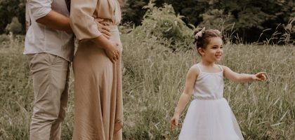 A family enjoying outdoor time with their child on a summer day.